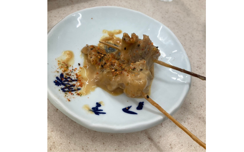 八重勝の名物・どて焼きをピリ辛味噌で味わう。濃厚な味わいがたまらない一皿。