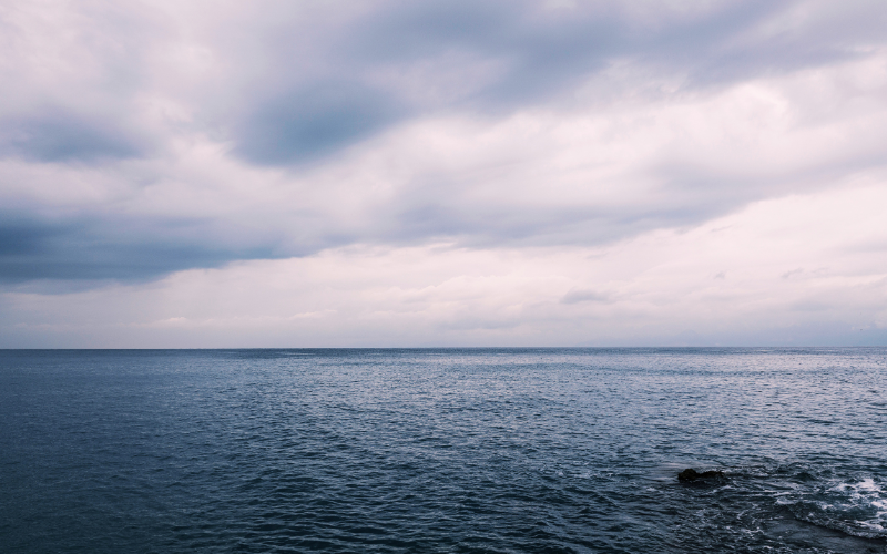 曇り空の下に静かに広がる穏やかな海