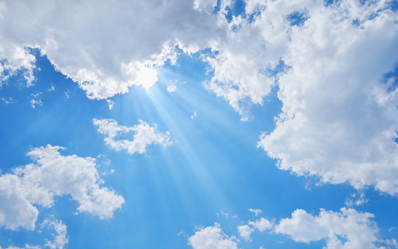 雲の切れ間から光が差し込む青空
