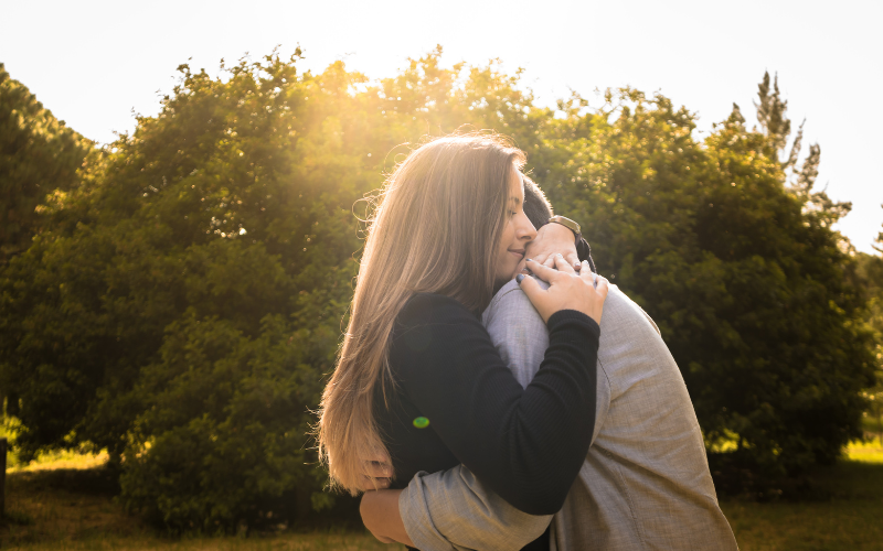 森で抱き合うカップル。二人の想いを共有している。